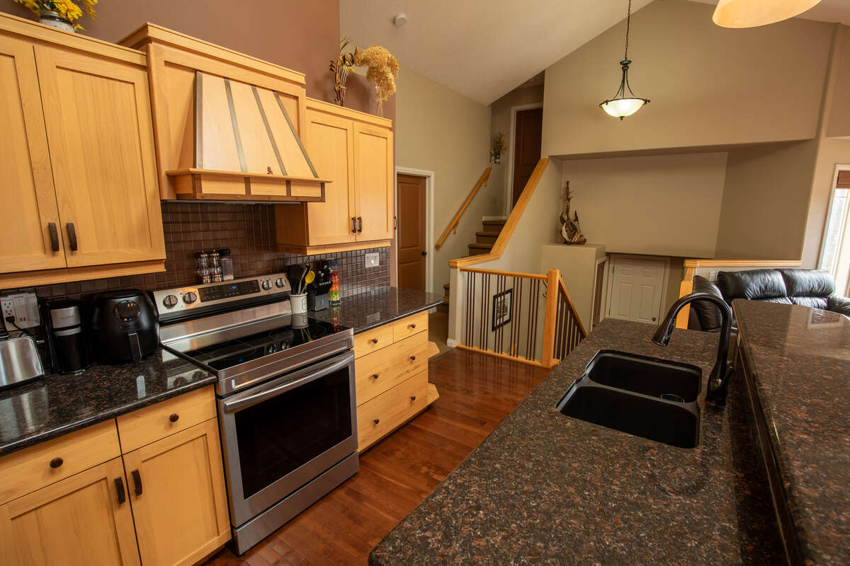 Large kitchen with two skylights, granite counter tops, pantry and new range