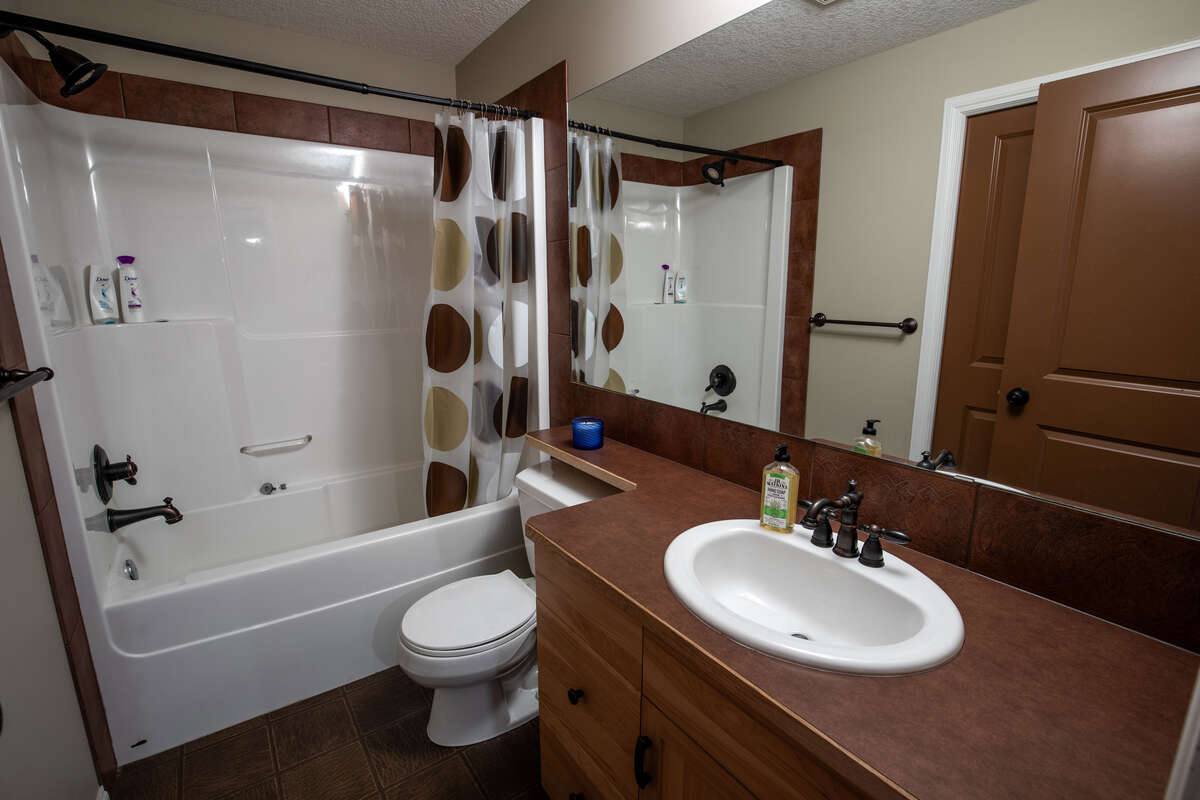 Full basement bathroom with connected doorway to bedroom