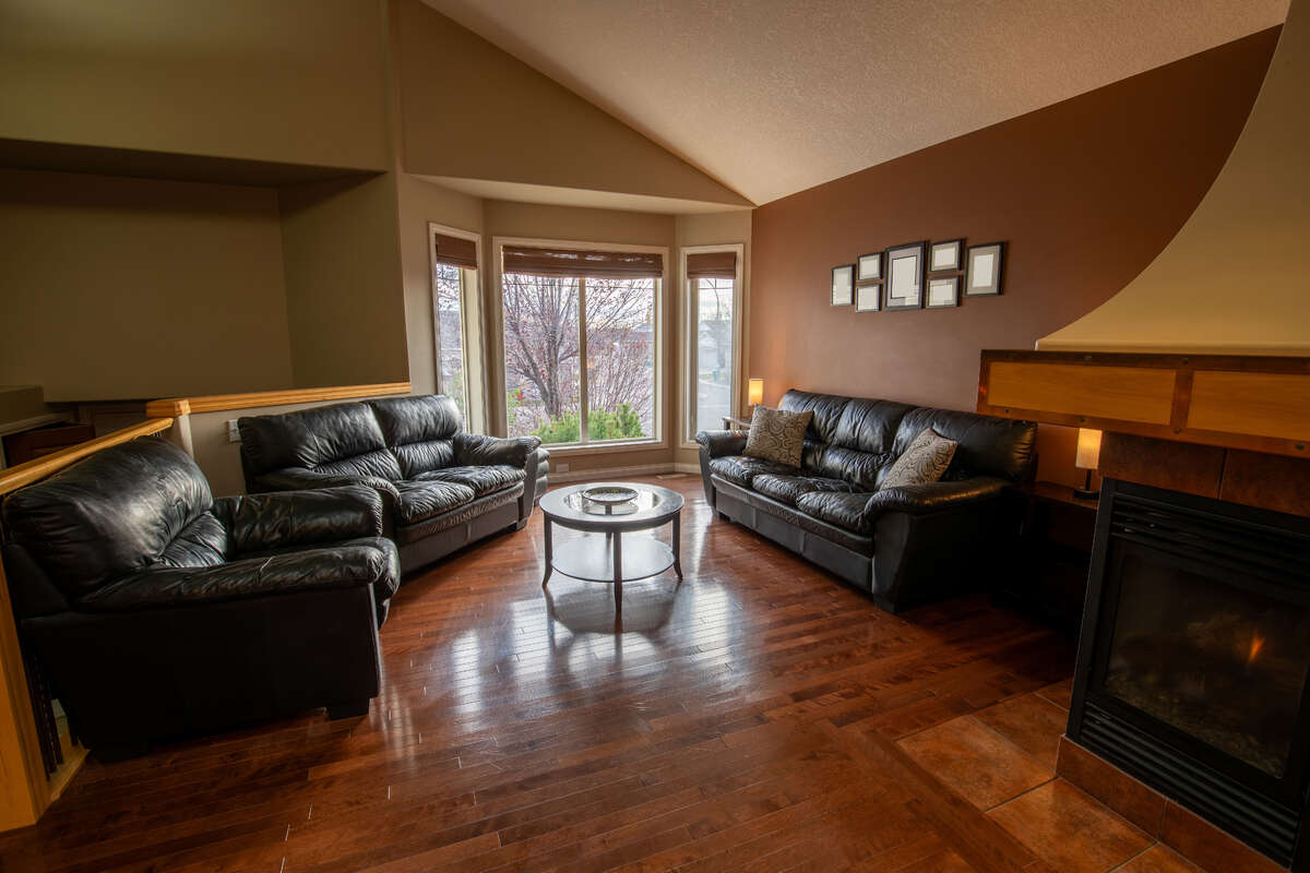 Open concept main floor with vaulted ceilings, hardwood floors and gas fireplace