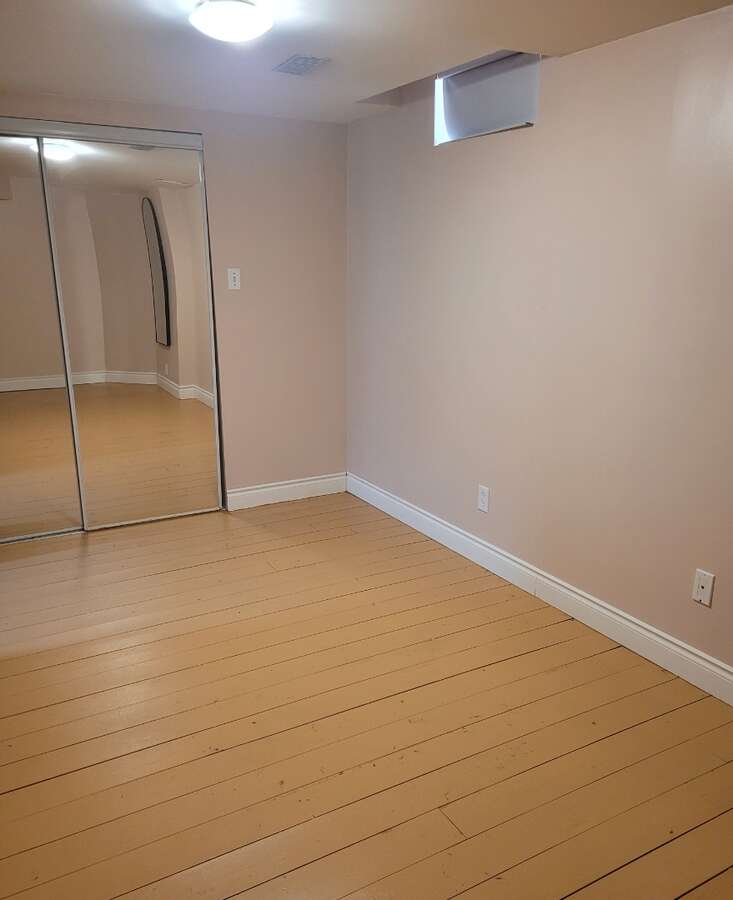 Apartment bedroom with mirrored closets, pine floors thru out