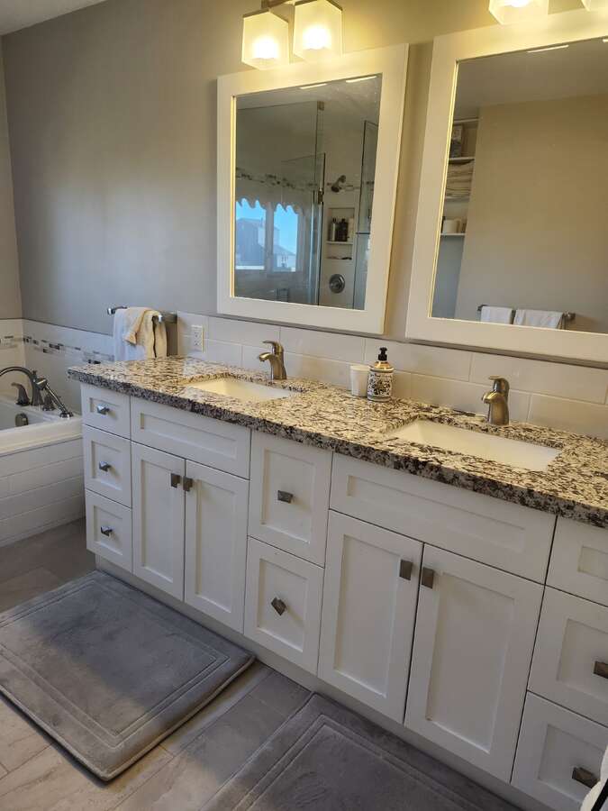 Master bedroom ensuite double sink vanity with tub and glass shower stall