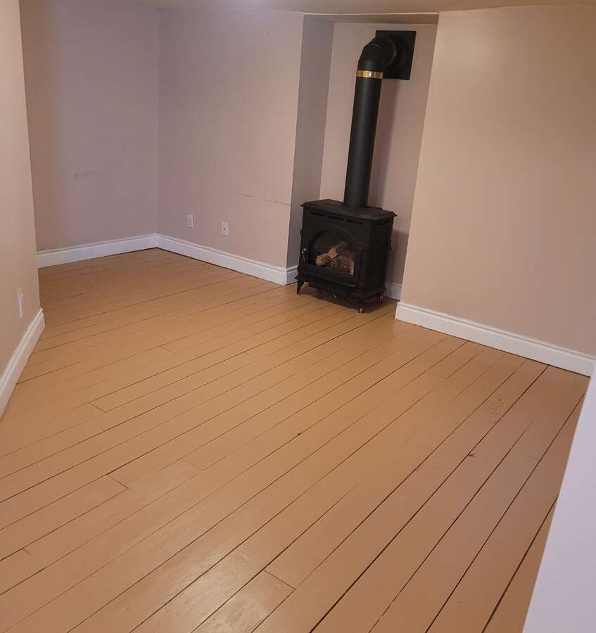 Basement unit living rm with gas fireplace and Two windows facing backyard