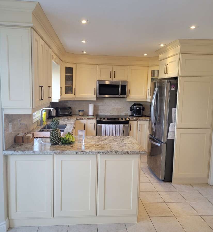 side view of kitchen, lots of cupboard space, fridge , stove, dishwasher all included