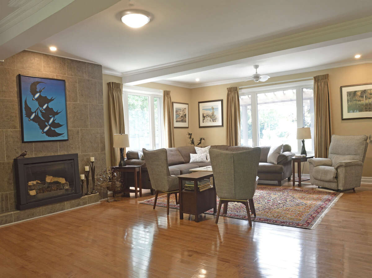 Another view of the expansive living room, featuring a cozy fireplace and abundant natural light.