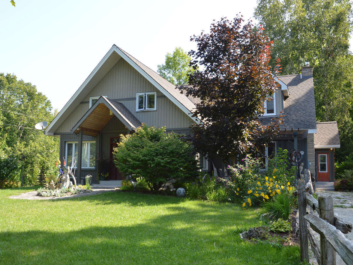 Charming Cottage Retreat: A beautifully landscaped entrance welcomes you to this peaceful home.