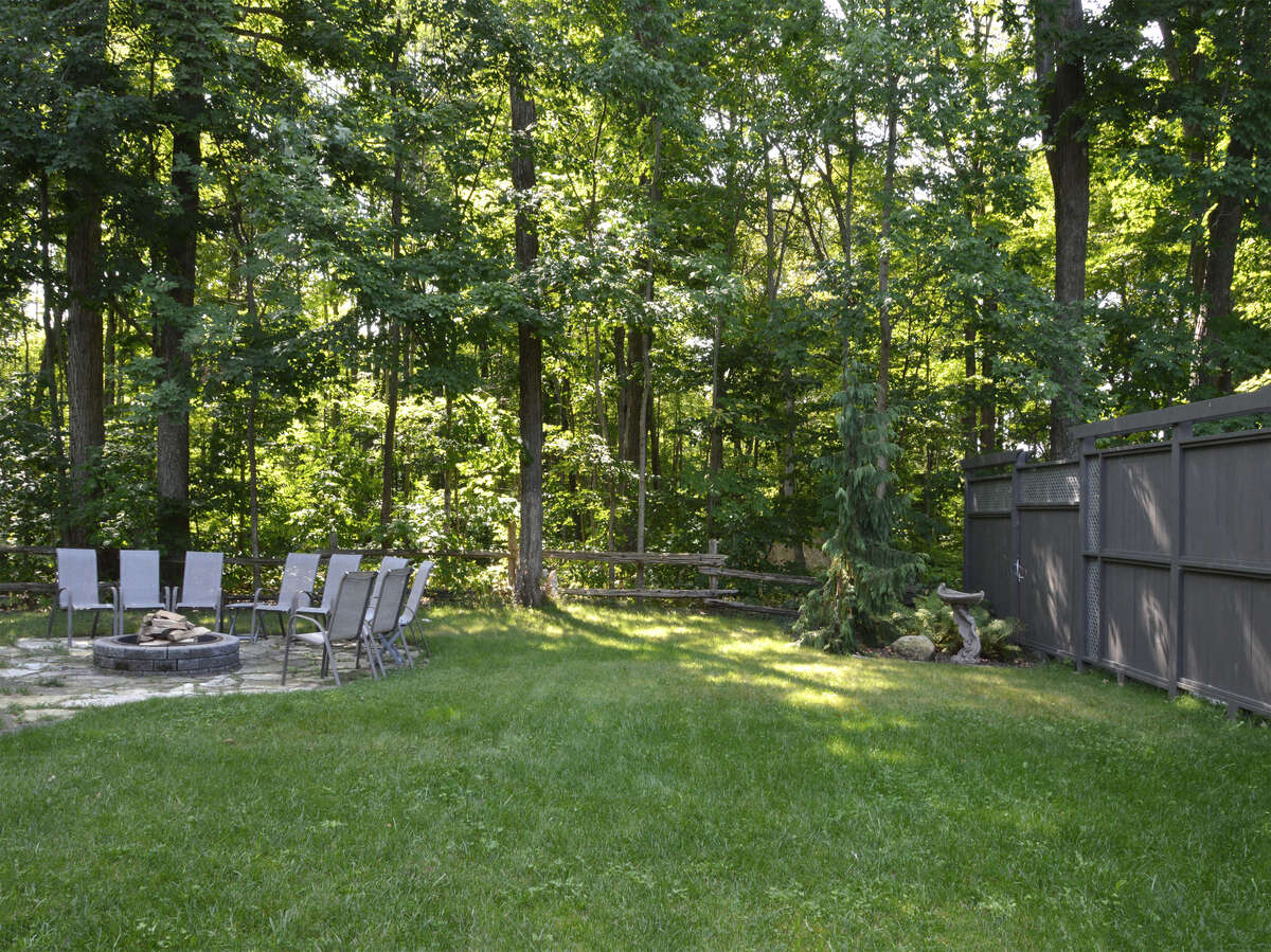 Spacious side yard with a large fire pit area, perfect for entertaining yet very private.