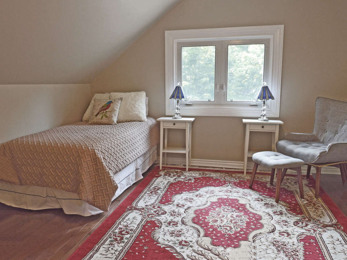 Bedroom 3: cozy bedroom with charming angled ceilings and a view of the main road. A guest room?