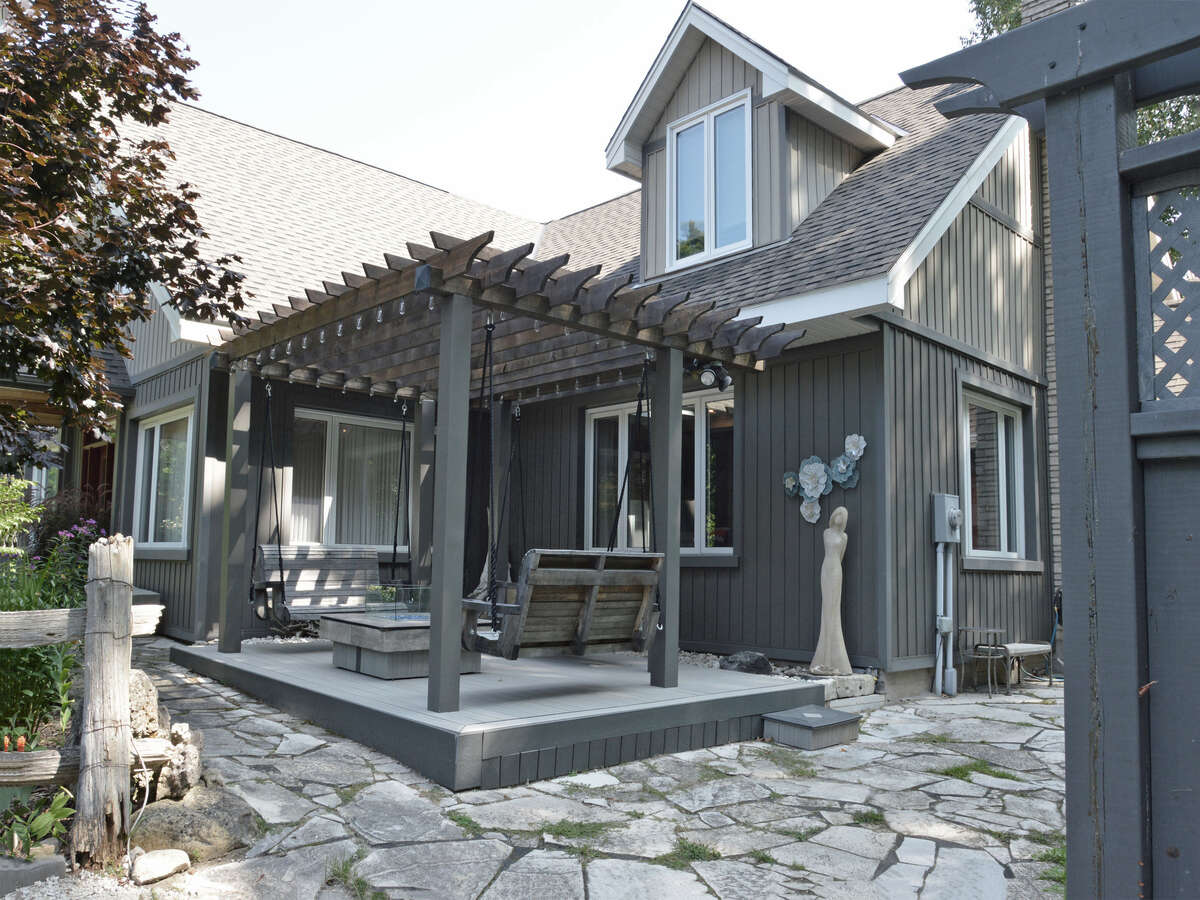 Inviting pergola deck with swings and a fire table, perfect for outdoor relaxation.