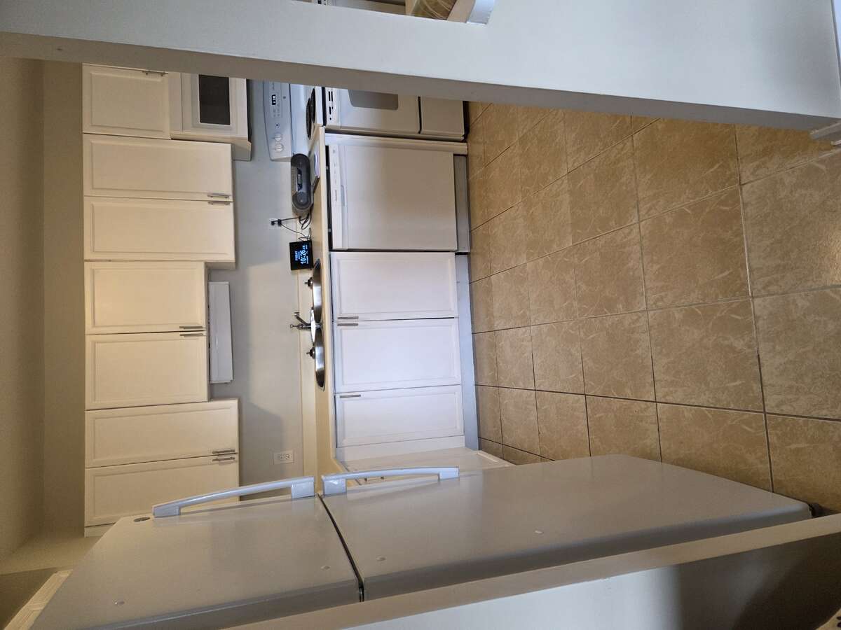 Top-freezer fridge convenient to living room/dining room