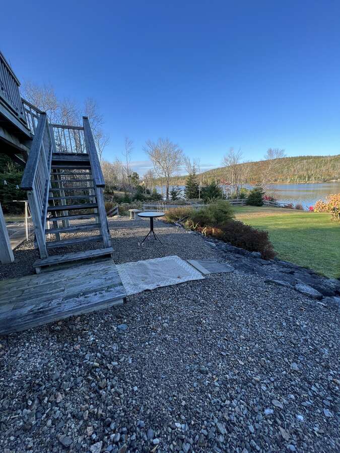 Stairs from wrap around upper deck to lower patio and lake