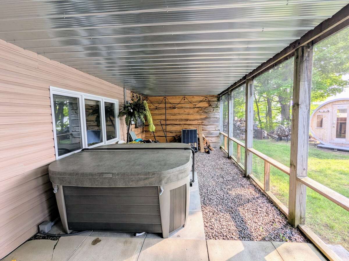Hot tub in screened-in porch below deck