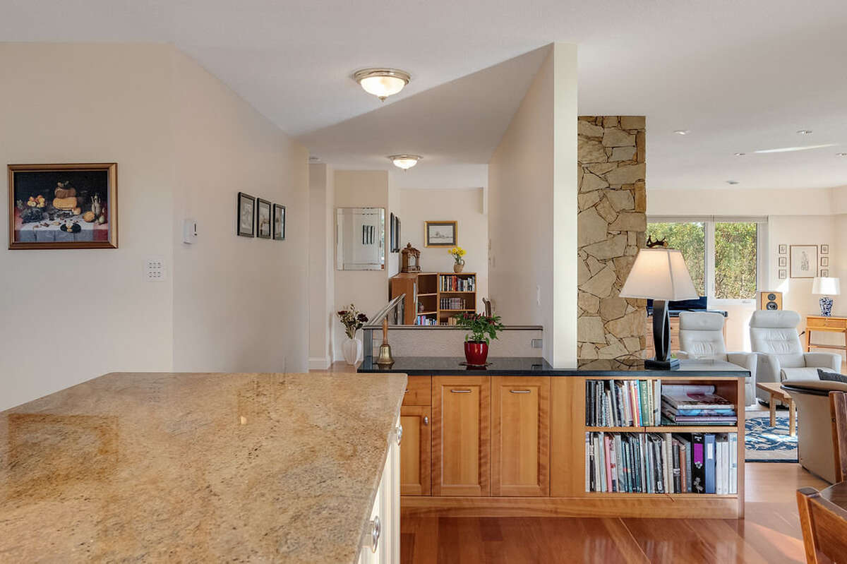 Two recycling bins are hidden inside cabinets beside the bookcase