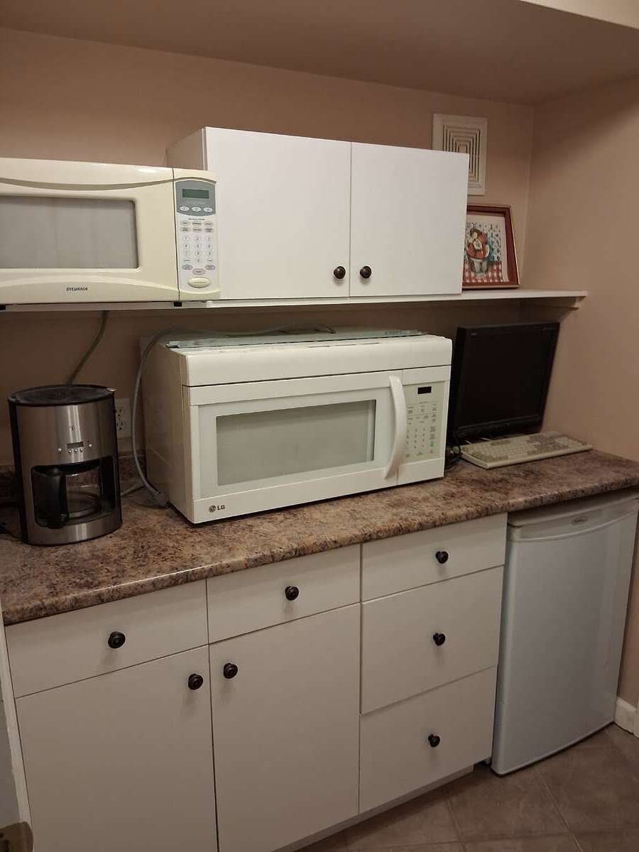 Small kitchenette with a small fridge and microwave. The bigger microwave is too big for here.