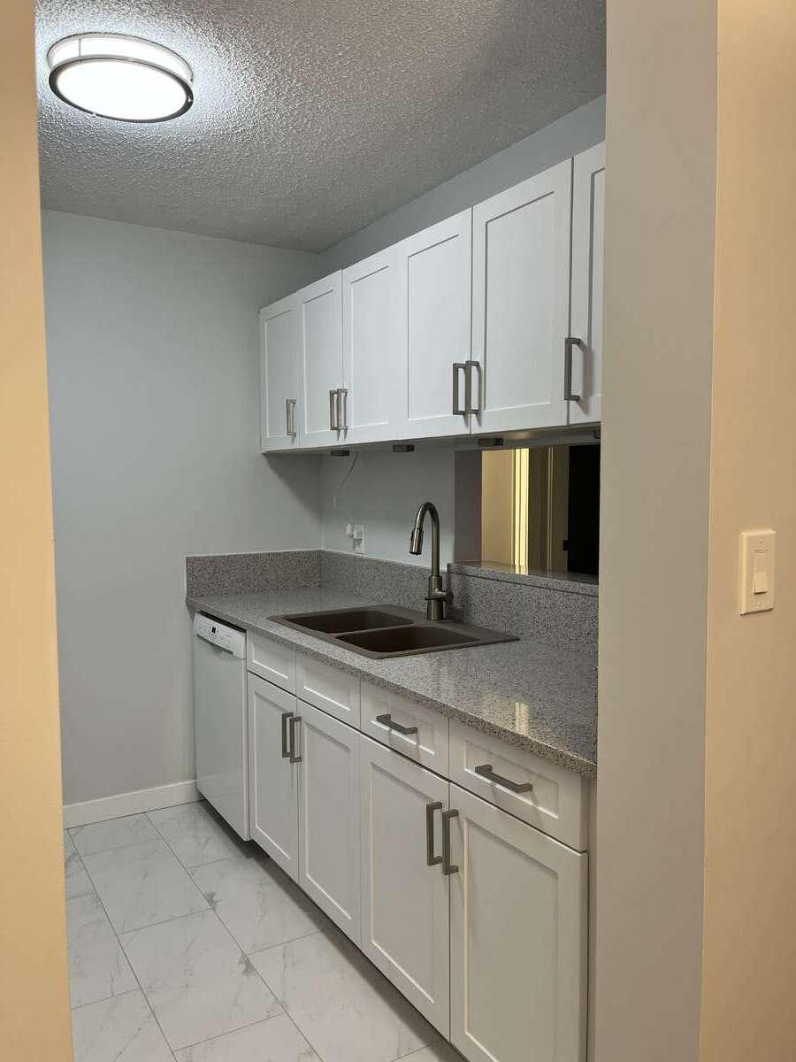 Kitchen with quartz counters with view into living room.