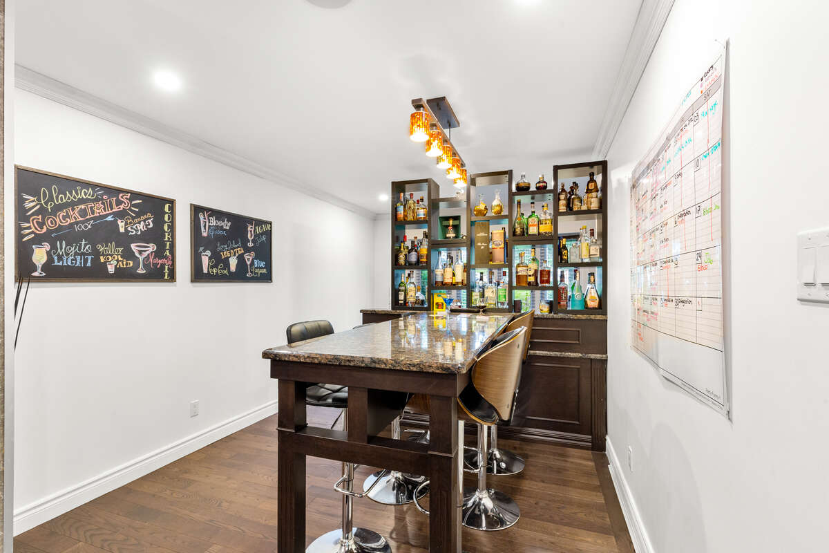 “Luxury Granite Bar with Seating and Custom Beverage Display”