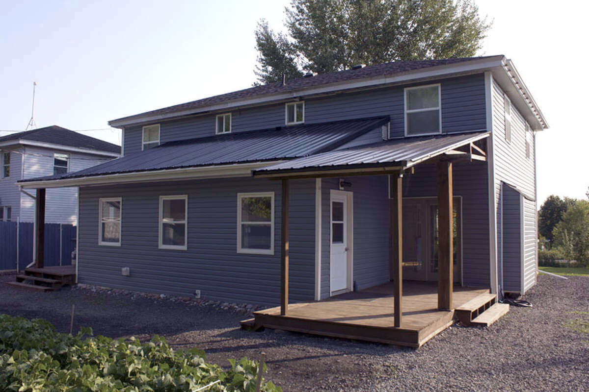 Rear view showing the addition, decks, and usable outdoor space.