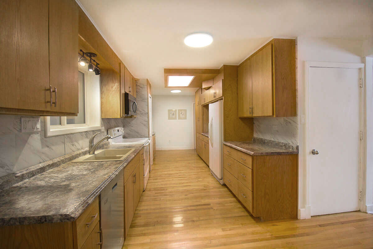 Updated kitchen with oak cabinetry and maple hardwood floor.