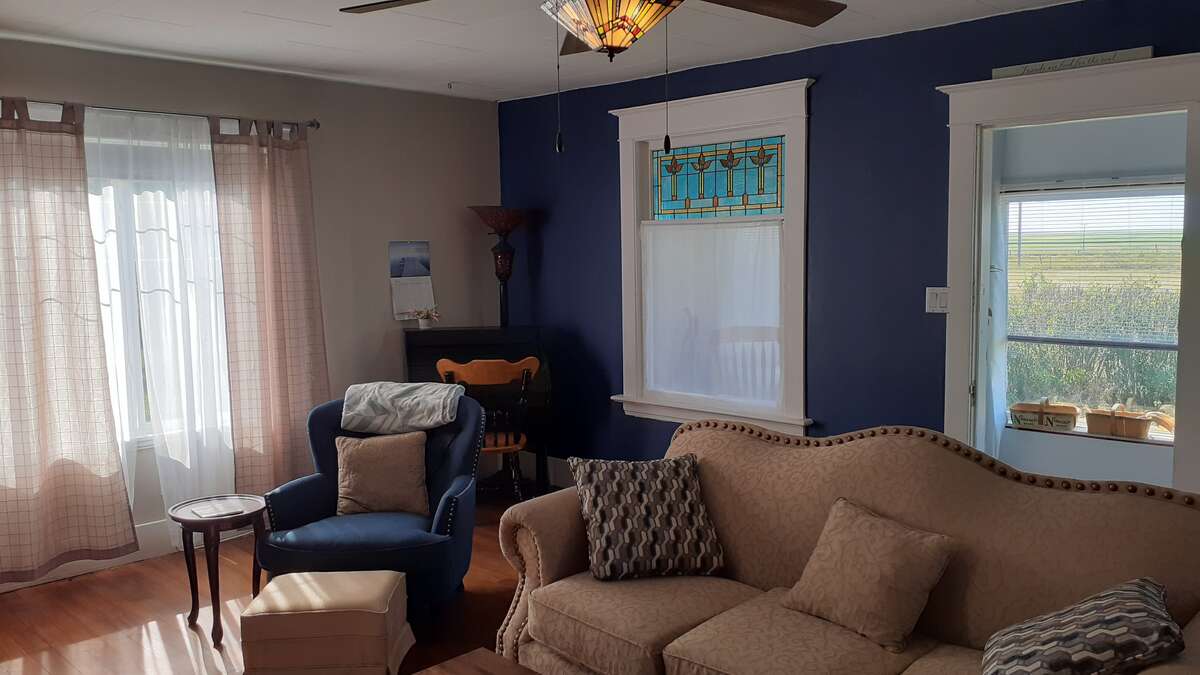 Living room facing South. Stained glass light/fan in ceiling
