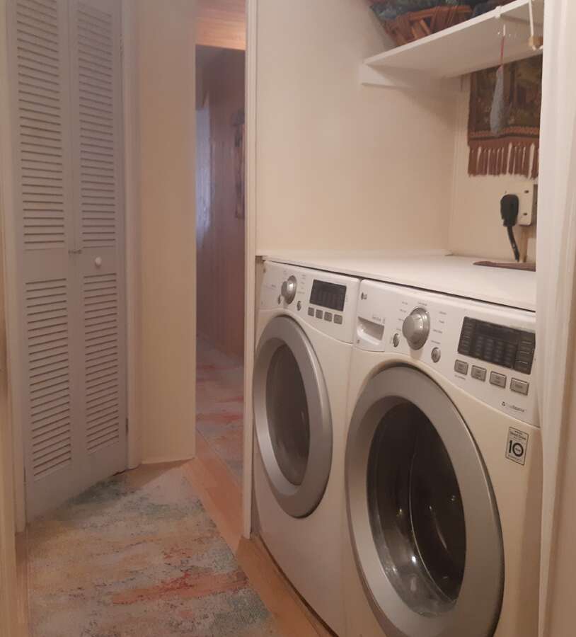 Laundry area with door to closet with shelves