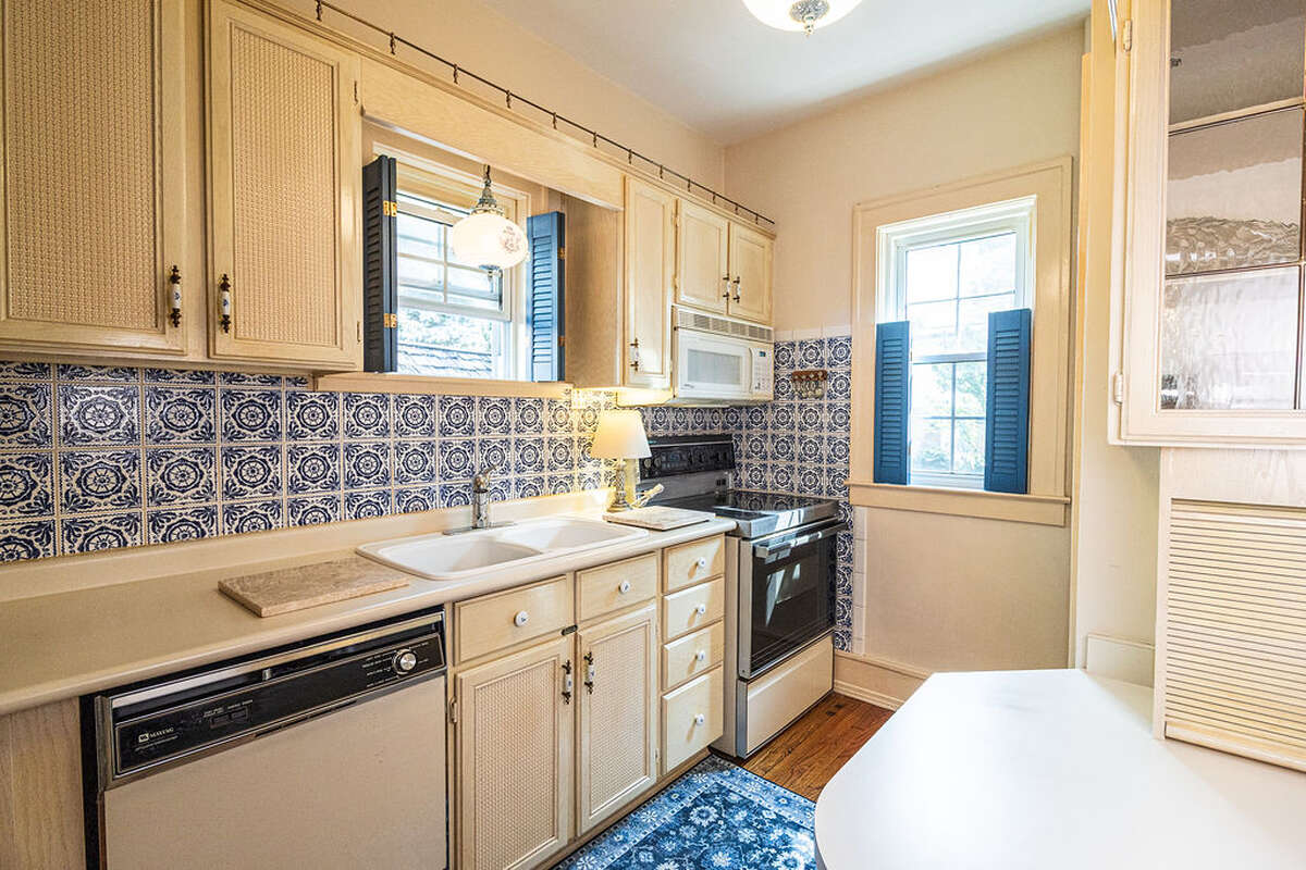 The kitchen is quaint and fully equipped, showcasing beautiful vintage cobalt blue and white tiles