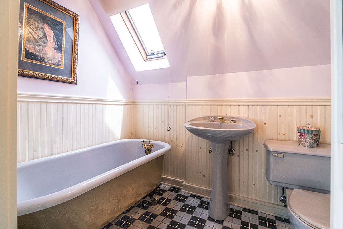 ensuite bathroom that includes a vintage clawfoot tub and iconic black-and-white checkered tiles