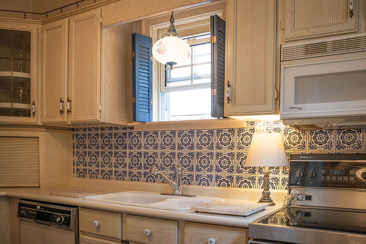The kitchen is quaint and fully equipped, showcasing beautiful vintage cobalt blue and white tiles