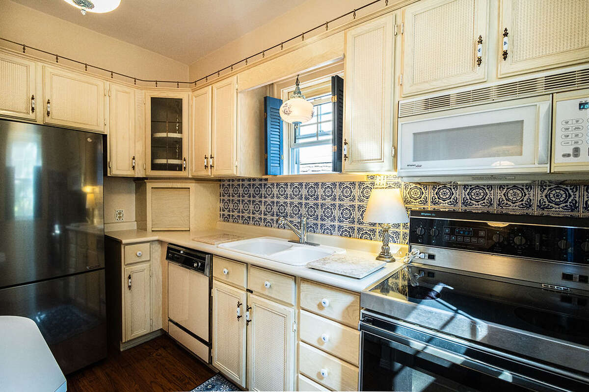 The kitchen is quaint and fully equipped, showcasing beautiful vintage cobalt blue and white tiles