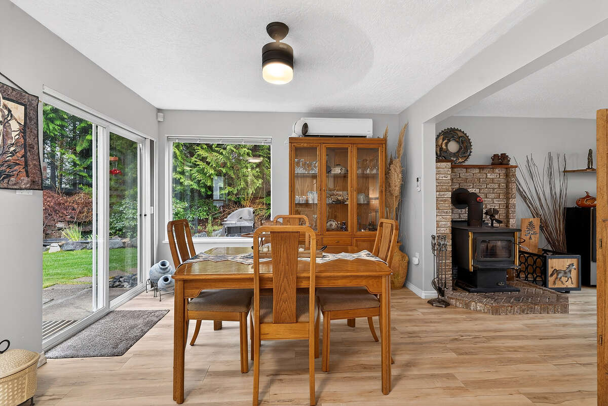 Dinning room with sliding doors to backyard patio, bbq area, gardens & wood shed.