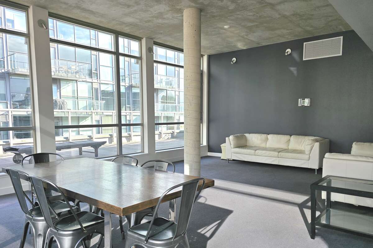 Bright and spacious communal lounge area with large windows and comfortable seating.