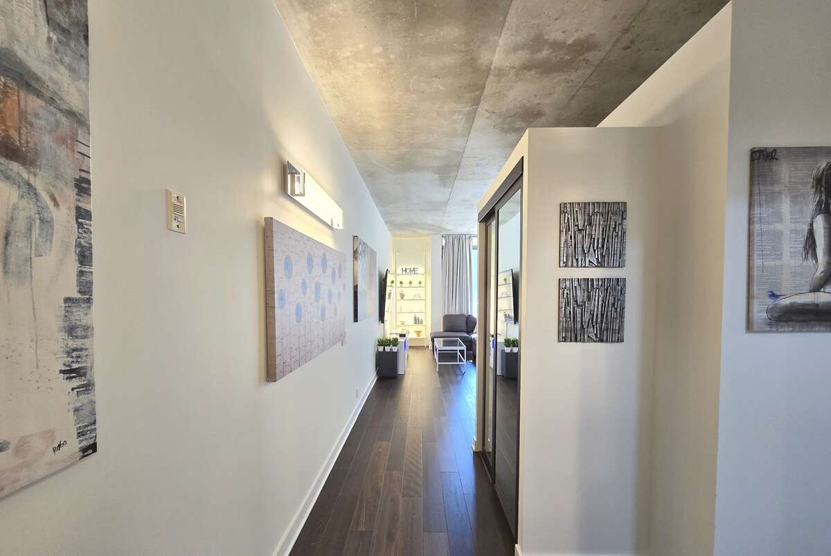 Spacious living area with floor-to-ceiling windows offering abundant natural light and access to a private balcony.