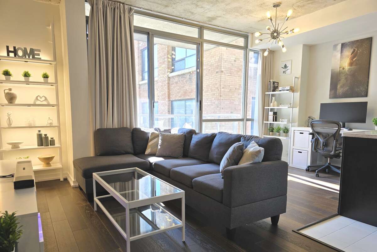Large windows and a private balcony provide ample natural light and outdoor space.