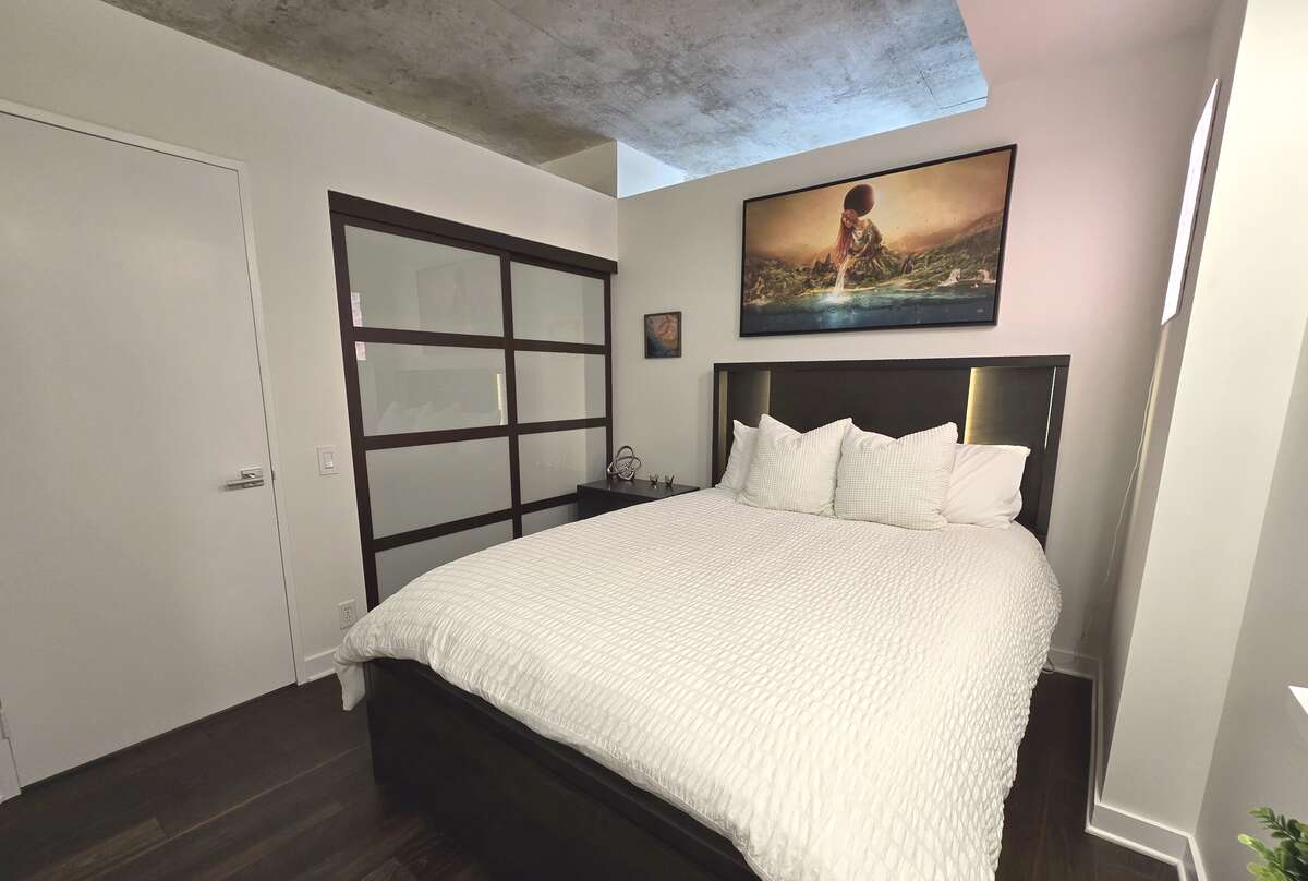 Modern spacious bedroom with frosted glass closet doors.
