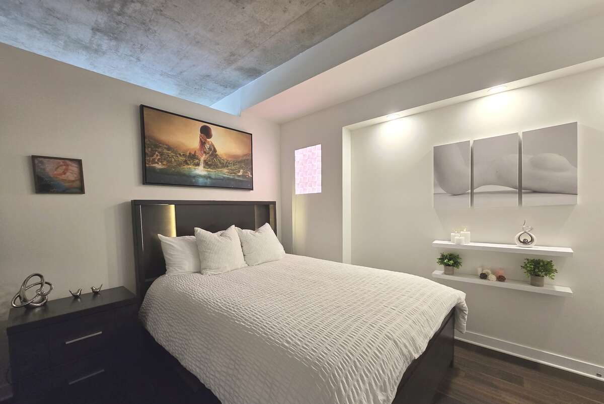 Comfortable bedroom with recessed lighting and built-in shelving.