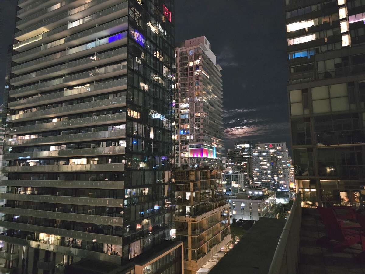 Impressive rooftop night view of city skyscrapers.