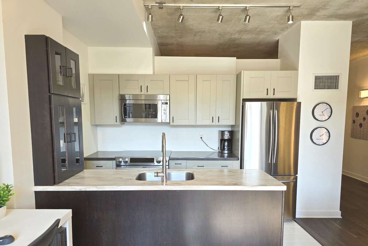 Bright kitchen area with integrated Samsung stainless steel appliances.