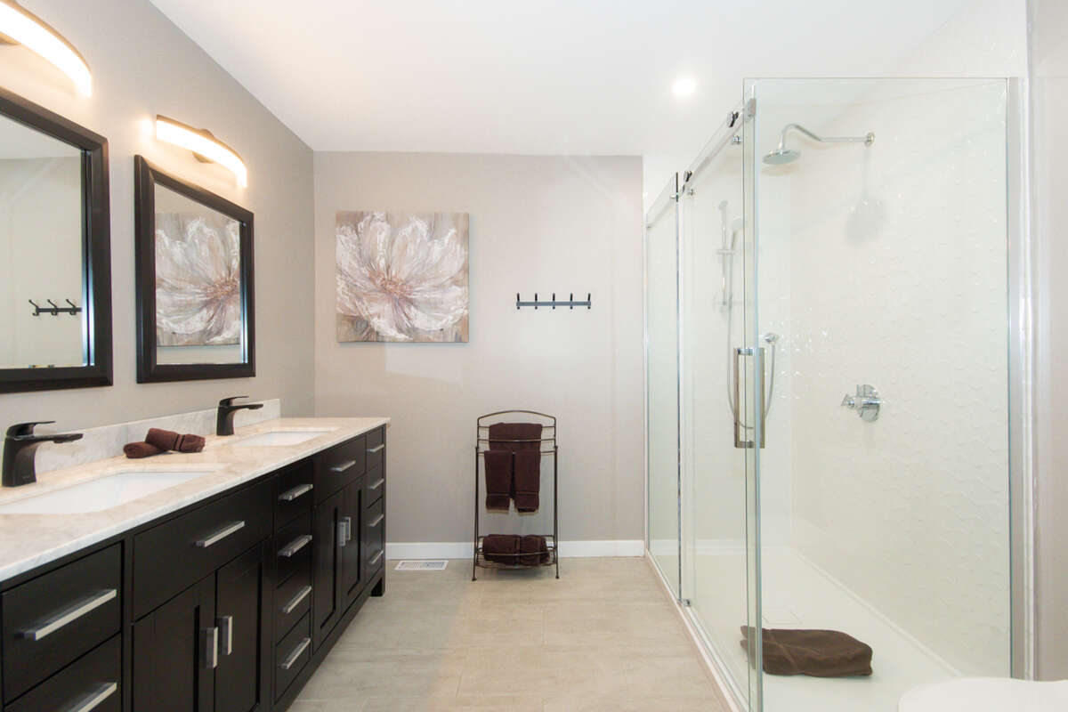Primary bedroom ensuite with double sink and walk-in shower