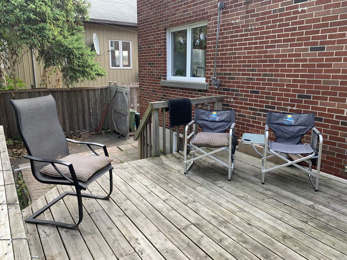 Backyard wood deck landing onto the lower deck tiles patio
