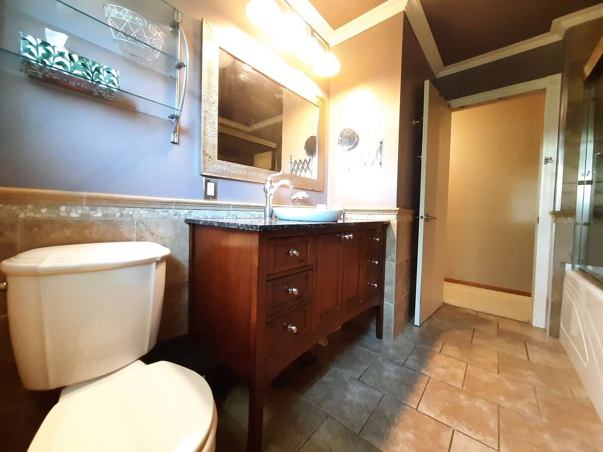 Vintage cabinet with marble top and half-sunk vessel sink.