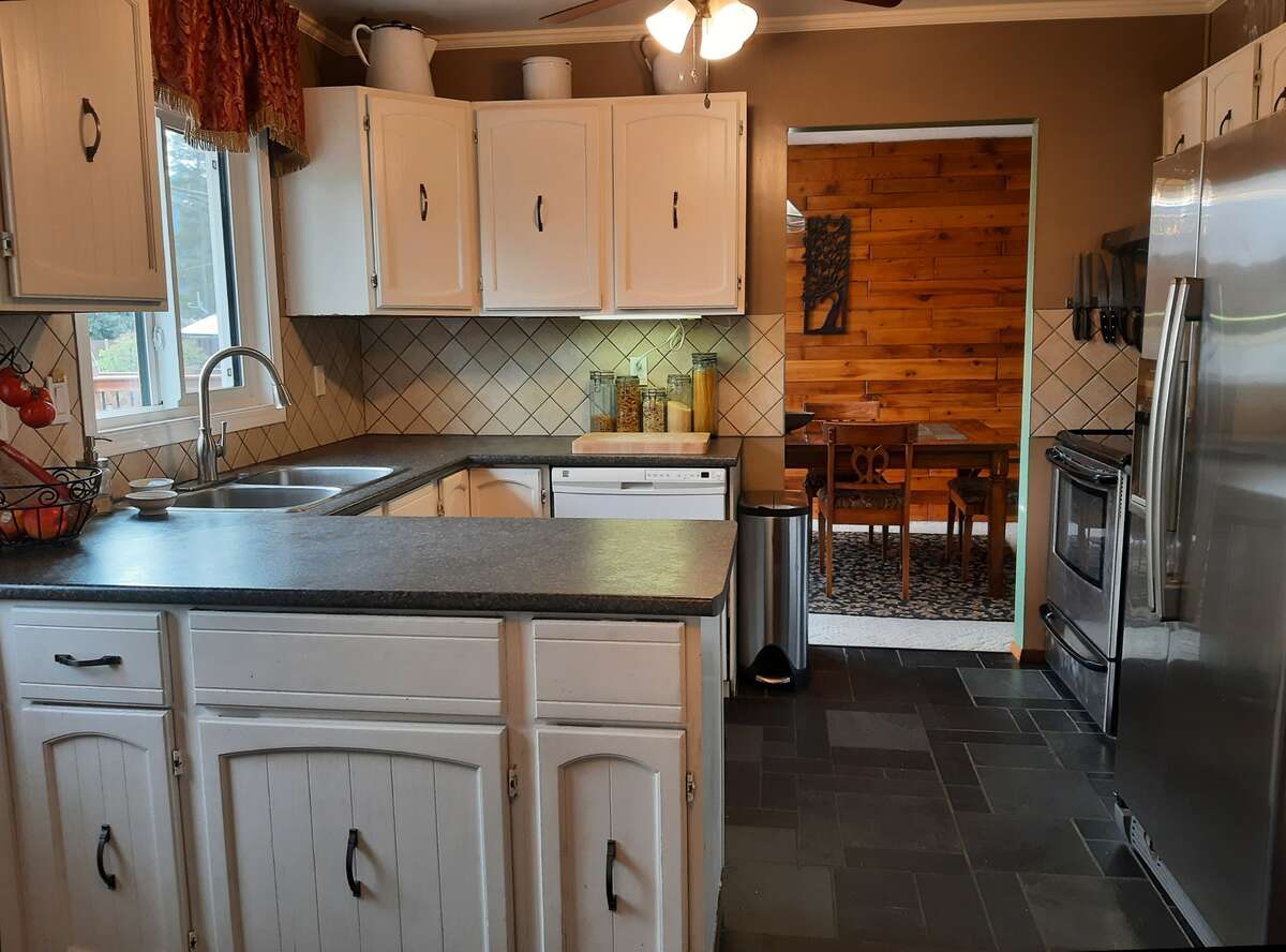 Custom slate tile flooring, stainless fridge & stove, white d/w and garburator.