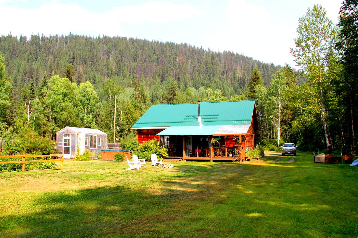 Behind house with baxk covered porch, green house, hot tub