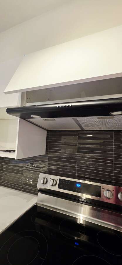 Sleek glass-mosaic backsplash with new rangehood