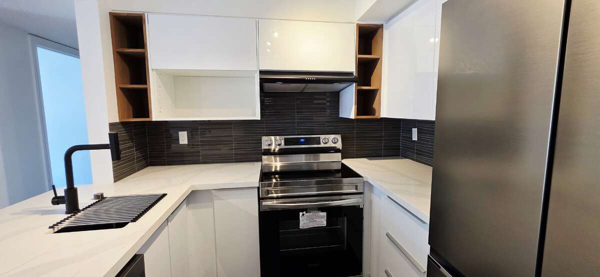High gloss white kitchen cabinets & drawers with wine shelves in wood accent