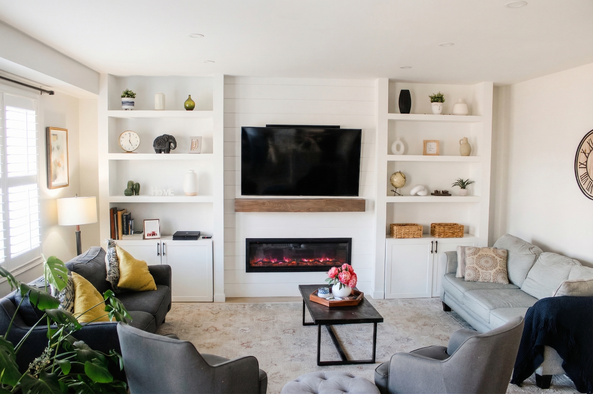 Living area with ornamental molding, electric fireplace, built-in modern wall, and recessed lighting