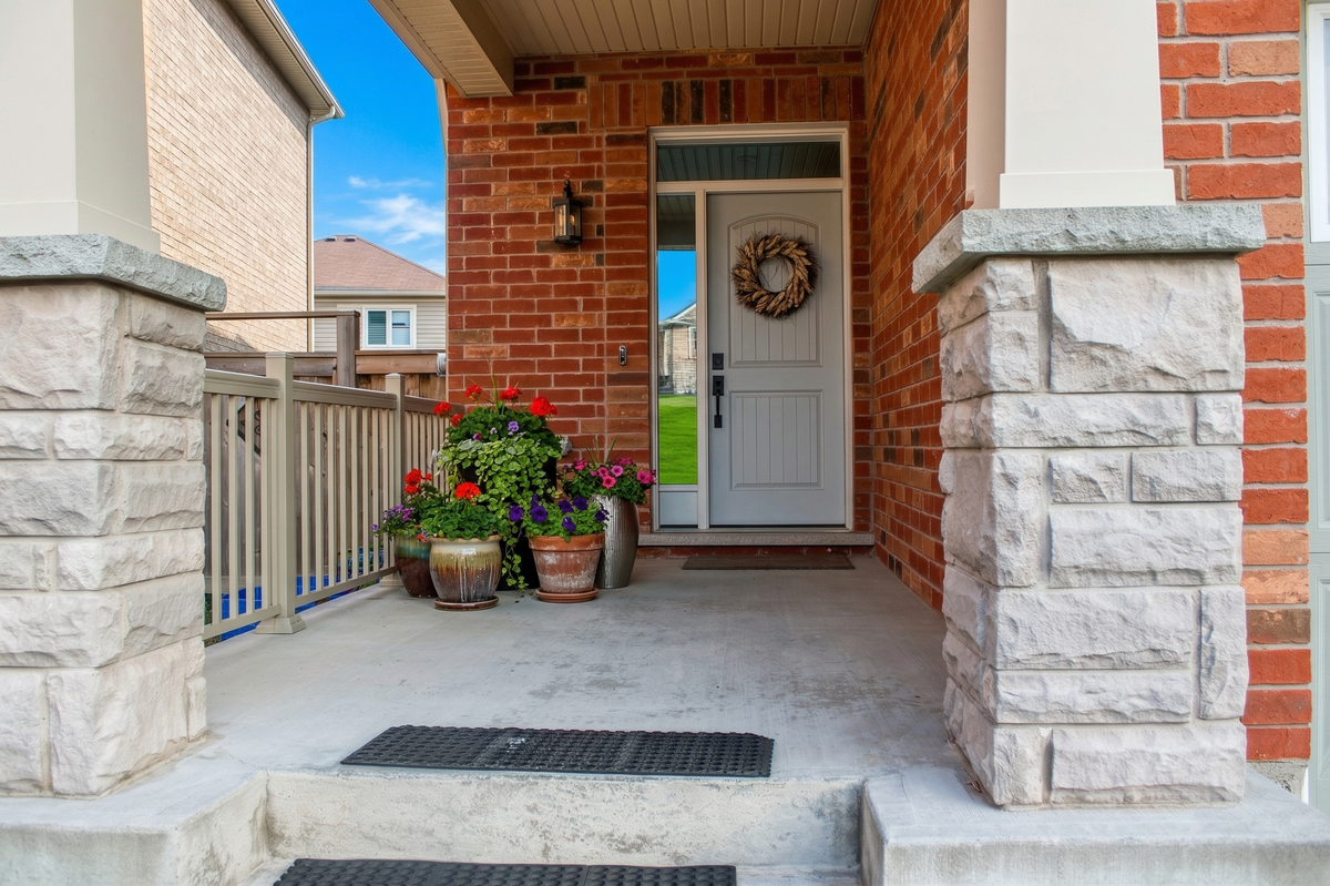 Stone entrance pillar, with white main entrance door, covered door way