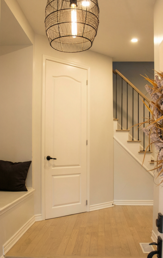 Foyer entrance featuring hanging lights, light brown flooring, plenty of natural light.