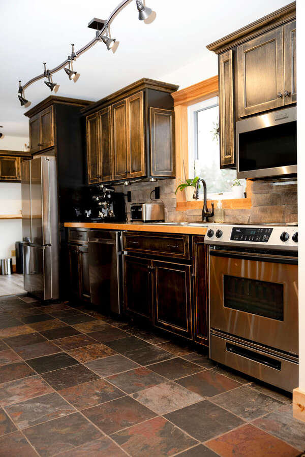 Custom cabinetry with stainless appliances and tile flooring