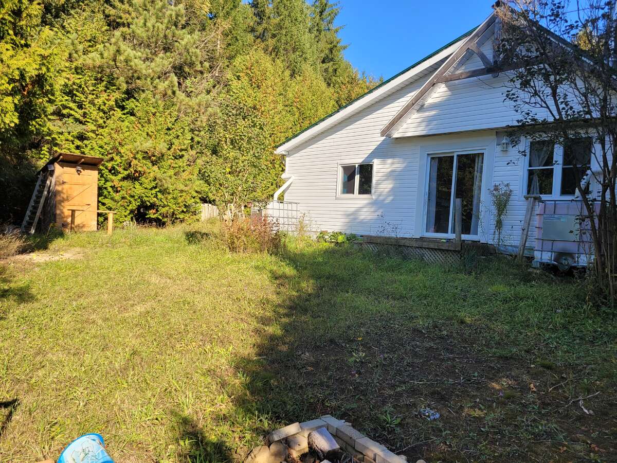 West facing of the cottage with the outhouse. Taken from small deck.