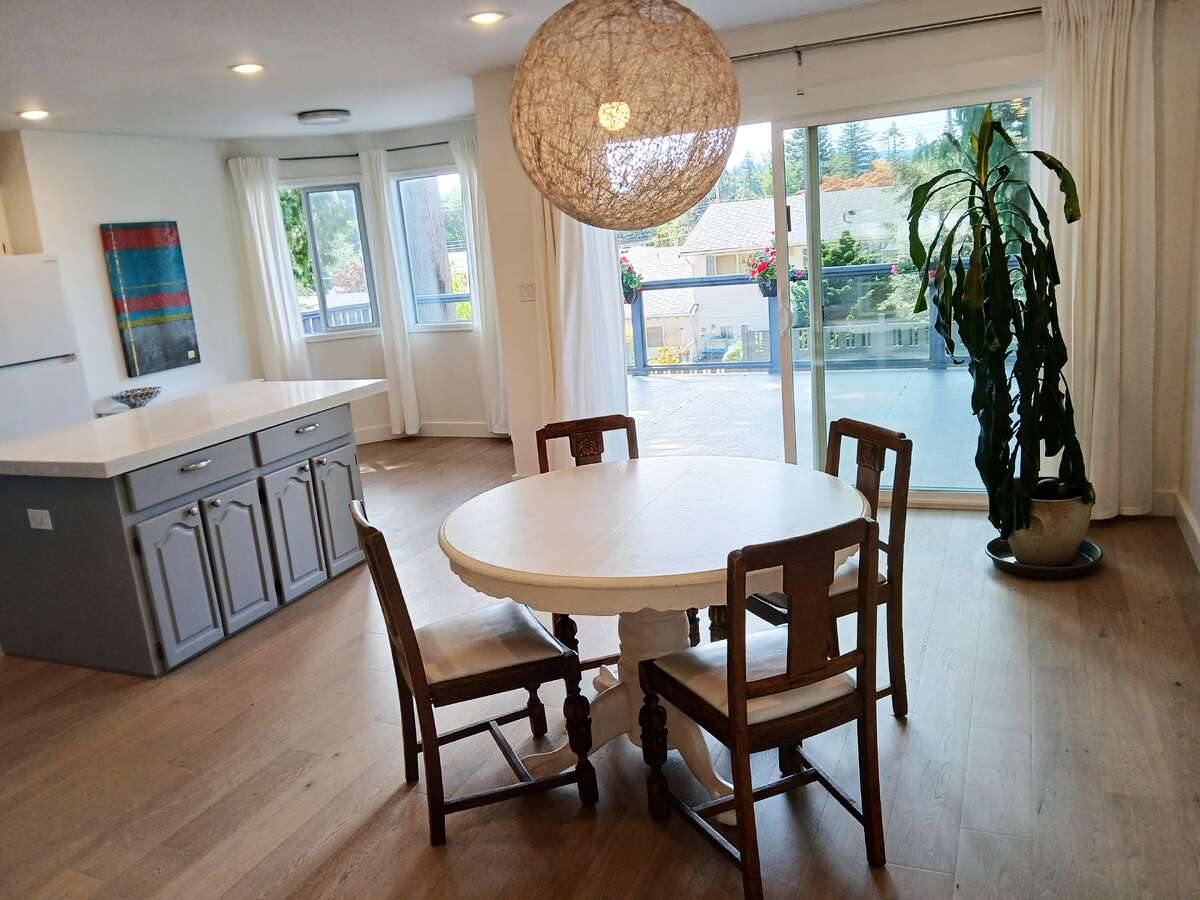 Dining area, kitchen to the left, eating nook to the centre and door to deck to the right.