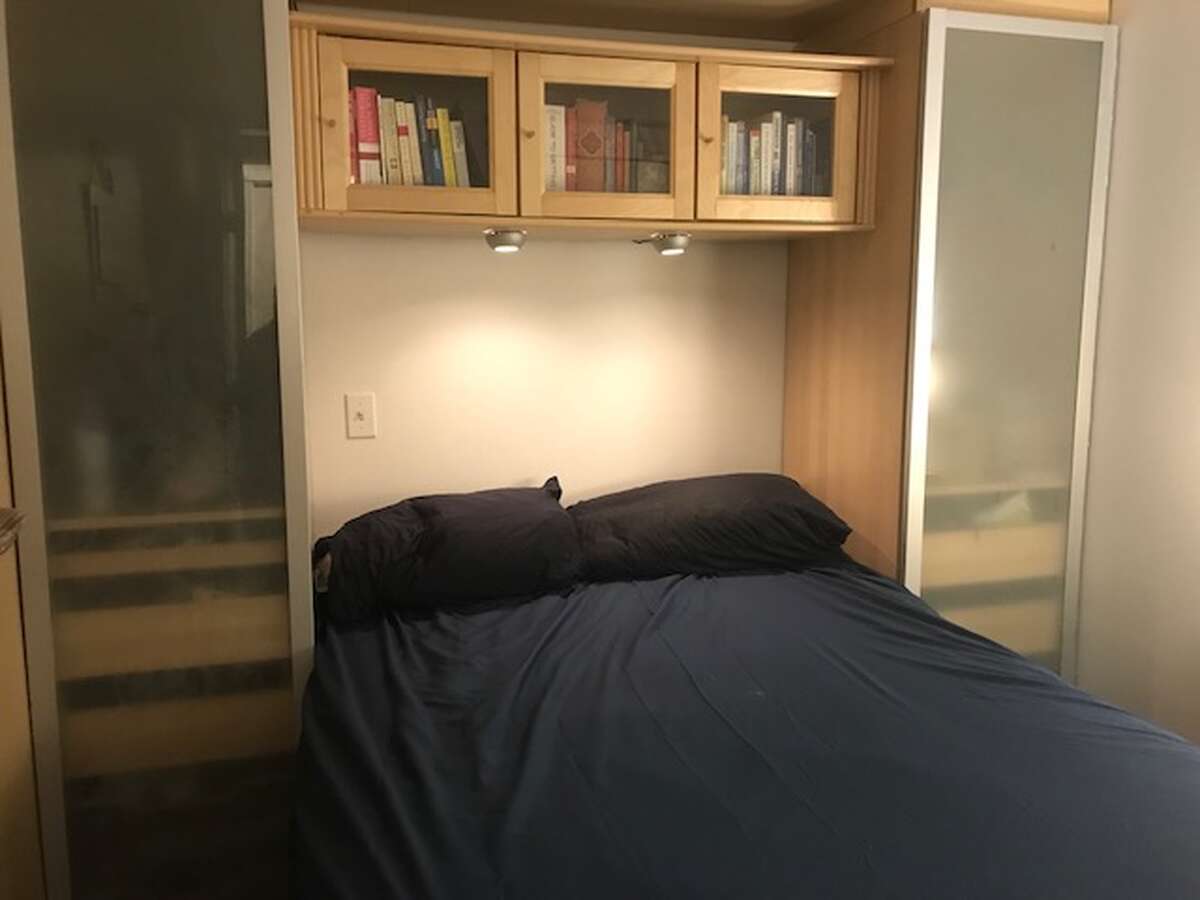 Bedroom with built-in shelving & lighting and a 24" TV