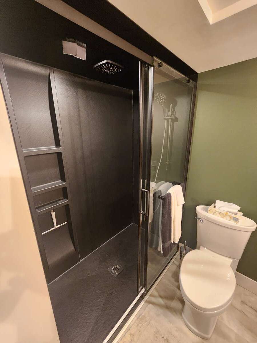 Updated 3pc lower bathroom with modern shower and rainhead showerheads.